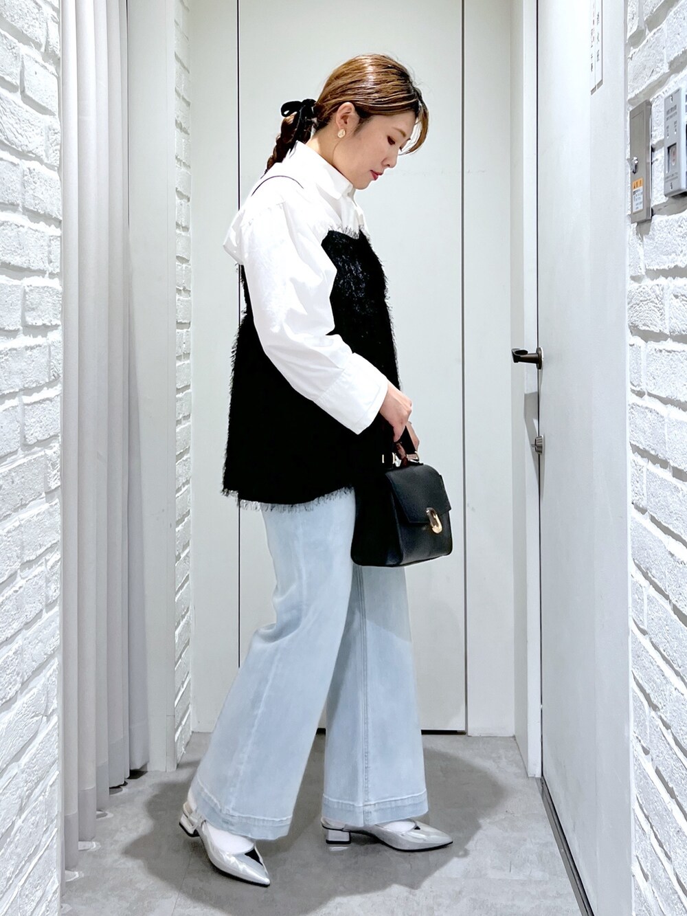 ブラック系のシャツ/ブラウス、ブルー系のデニムパンツ、シルバー系のパンプスを着用したレディースの冬コーディネートの3枚目の写真