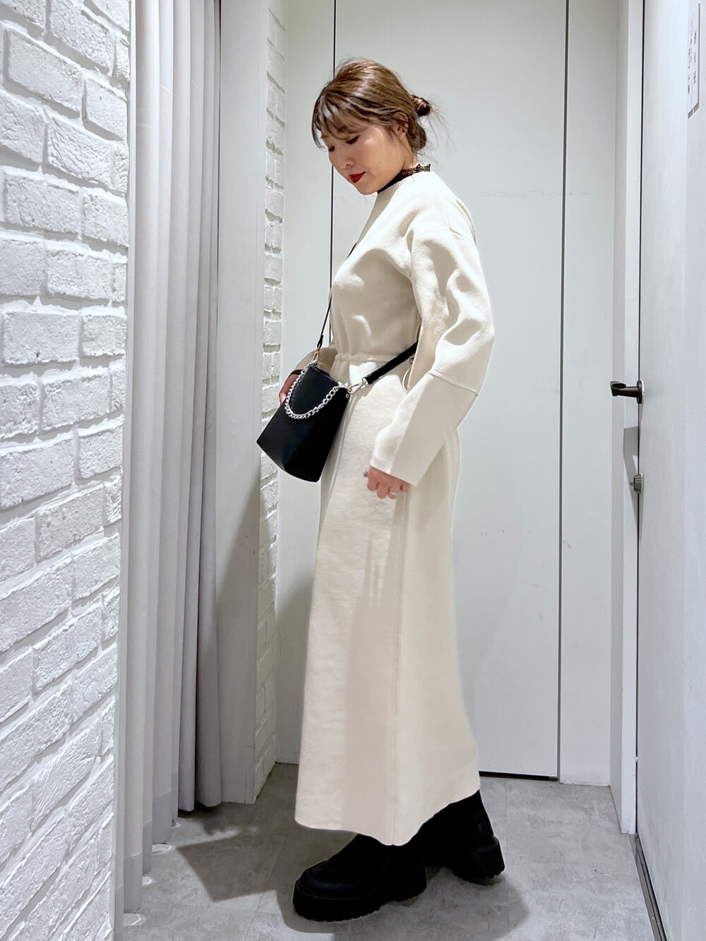 ホワイト系のワンピース、ブラック系のショルダーバッグ、ブラック系のTシャツ/カットソーを着用したレディースの冬コーディネートの3枚目の写真