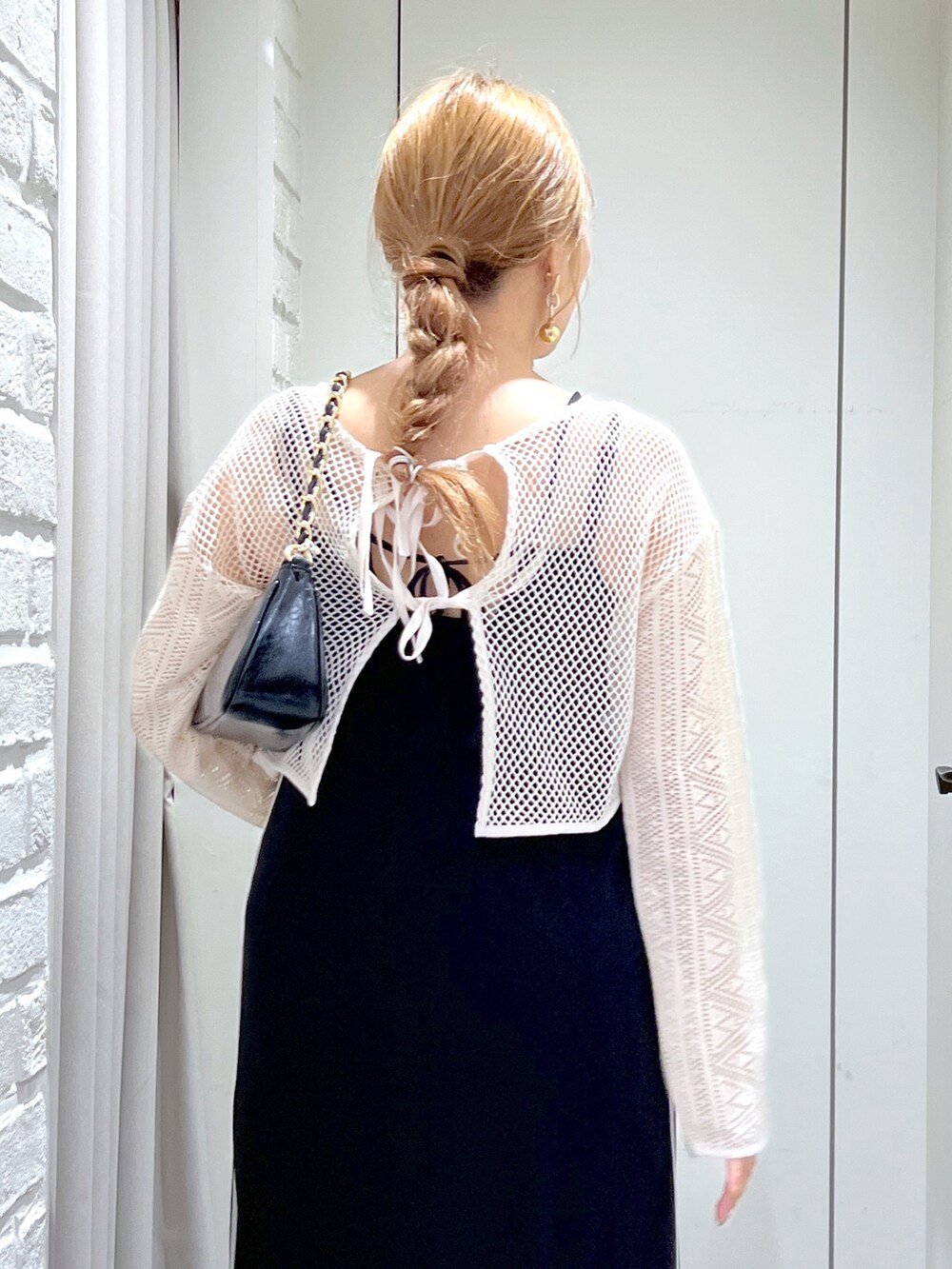 ブラック系のワンピース、ホワイト系のカーディガン/ボレロ、ブラック系のトートバッグを着用したレディースの夏コーディネートの9枚目の写真