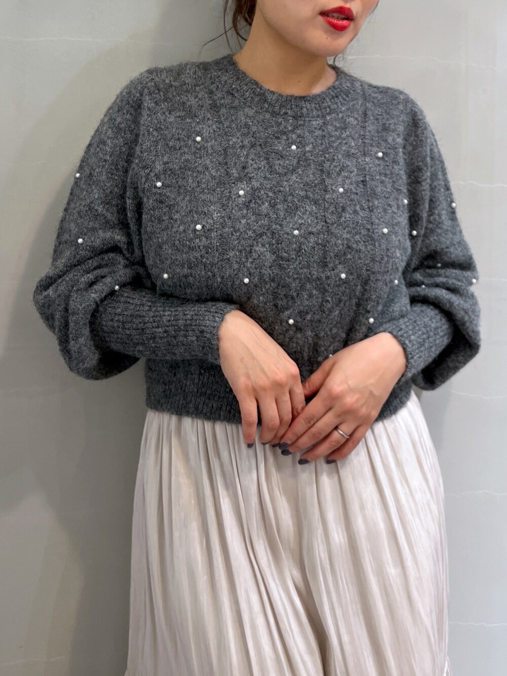 ホワイト系のスカート、グレー系のニット/セーター、ブラック系のショルダーバッグを着用したレディースの冬コーディネートの7枚目の写真