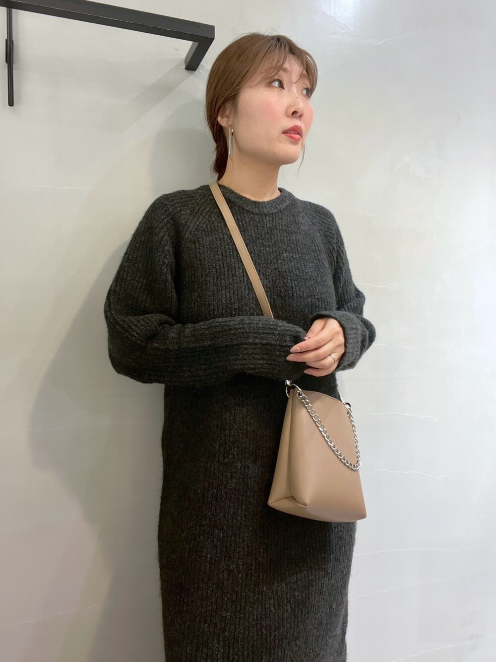 ブラック系のワンピース、ホワイト系のスニーカー、ベージュ系のショルダーバッグを着用したレディースの冬コーディネートの8枚目の写真