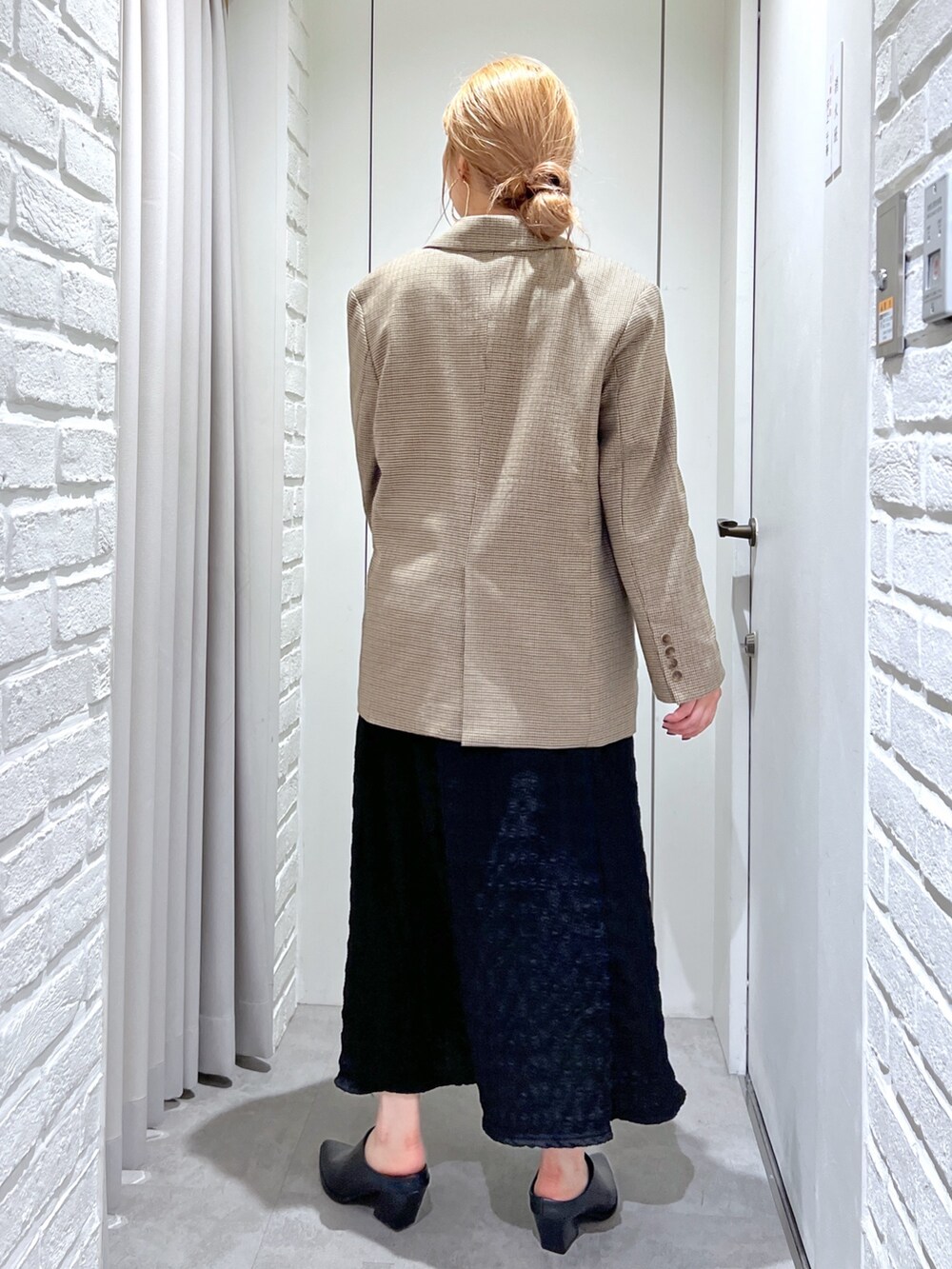 ブラック系のワンピース、ブラック系のパンプス、ゴールド系のショルダーバッグを着用したレディースの春コーディネートの10枚目の写真