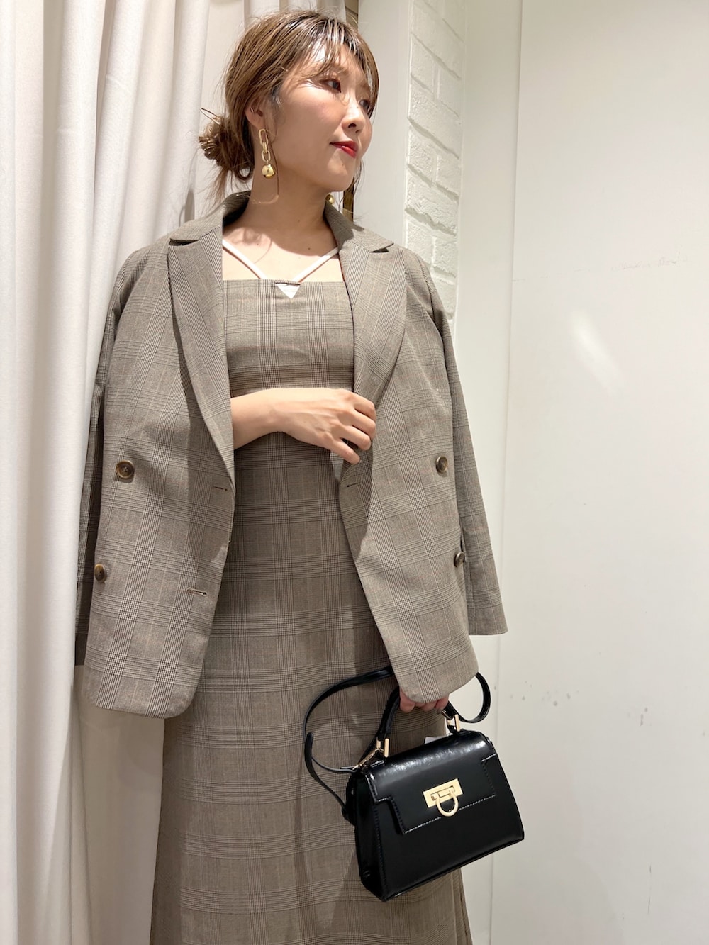 ブラウン系のテーラードジャケット、ブラウン系のワンピース、ブラウン系のサンダルを着用したレディースの秋コーディネートの3枚目の写真