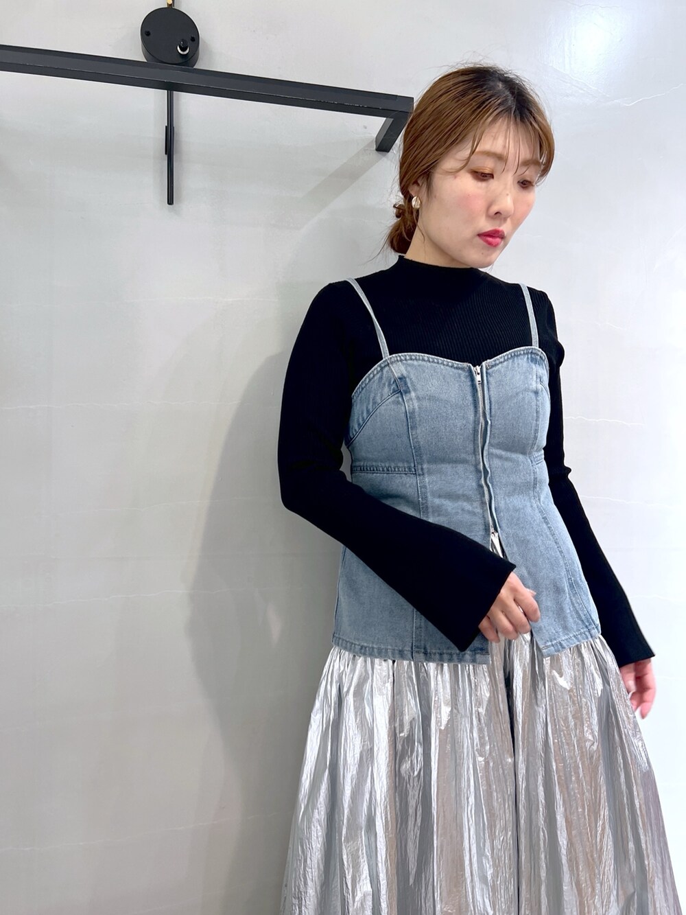 シルバー系のスカート、ブルー系のベスト、ブラック系のニット/セーターを着用したレディースの春コーディネートの7枚目の写真