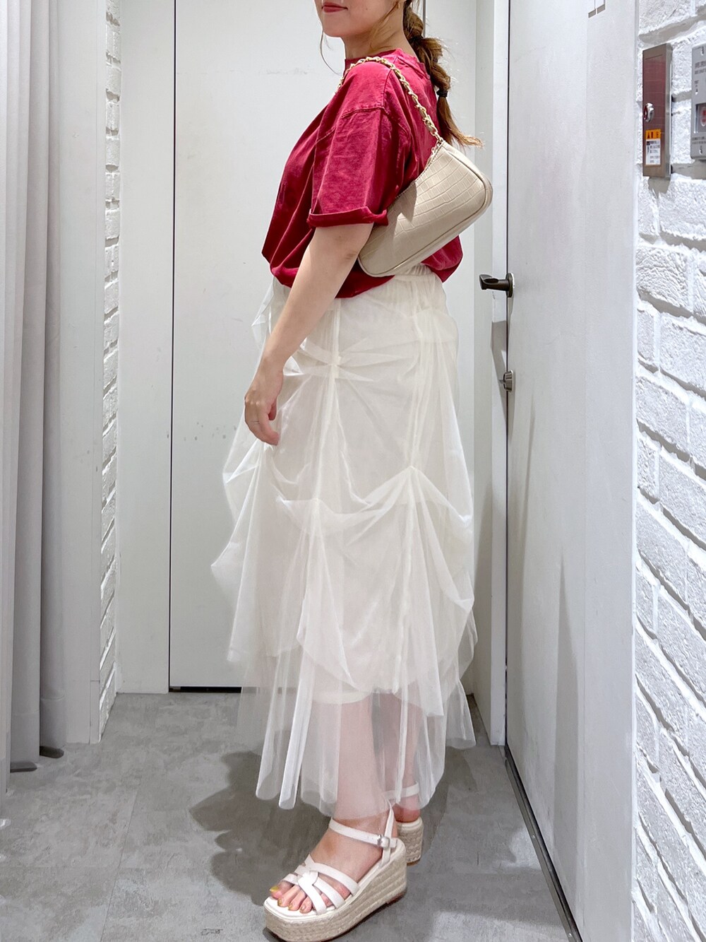 ホワイト系のスカート、レッド系のTシャツ/カットソー、ホワイト系のサンダルを着用したレディースの夏コーディネートの6枚目の写真