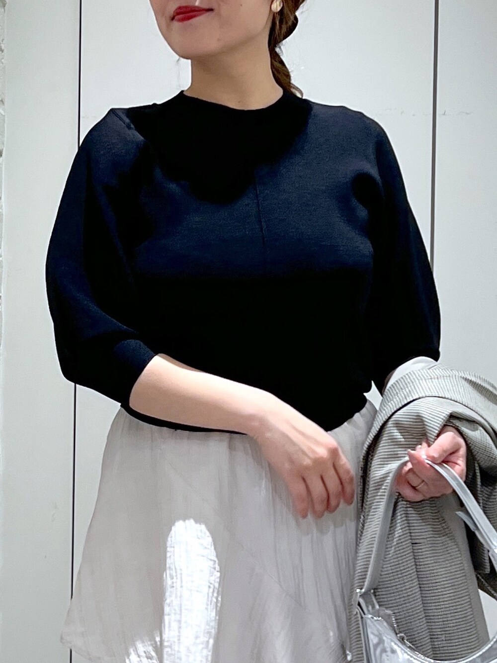 ブラウン系のテーラードジャケット、ホワイト系のスカート、ブラック系のパンプスを着用したレディースの春コーディネートの6枚目の写真