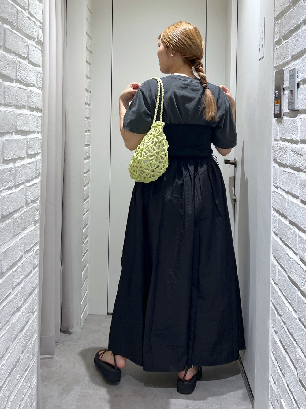 ブラック系のワンピース、ブラック系のTシャツ/カットソー、グリーン系のかごバッグを着用したレディースの夏コーディネートの4枚目の写真