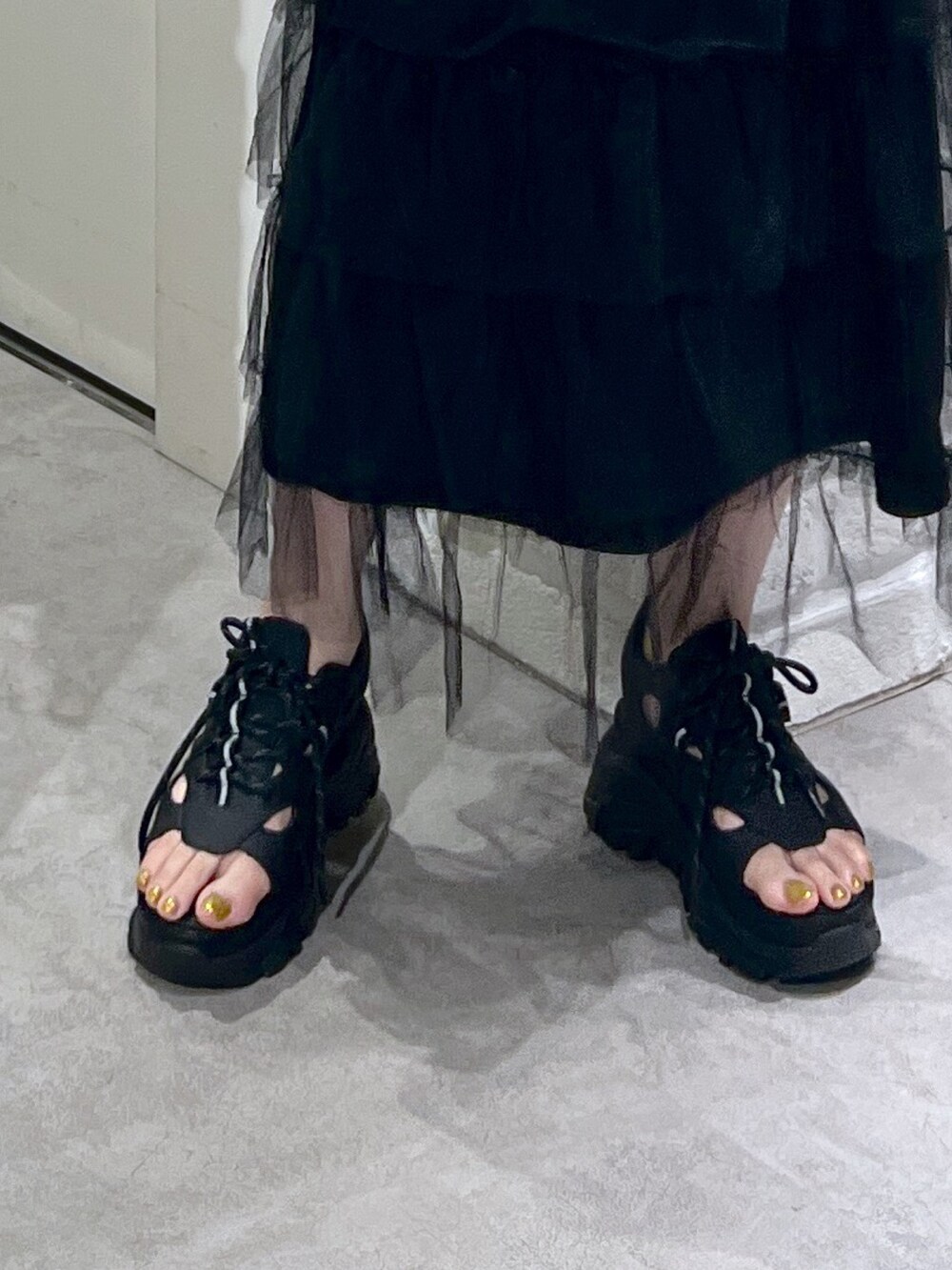 ブラック系のスカート、ブラック系のサンダル、ブラック系のショルダーバッグを着用したレディースの夏コーディネートの7枚目の写真