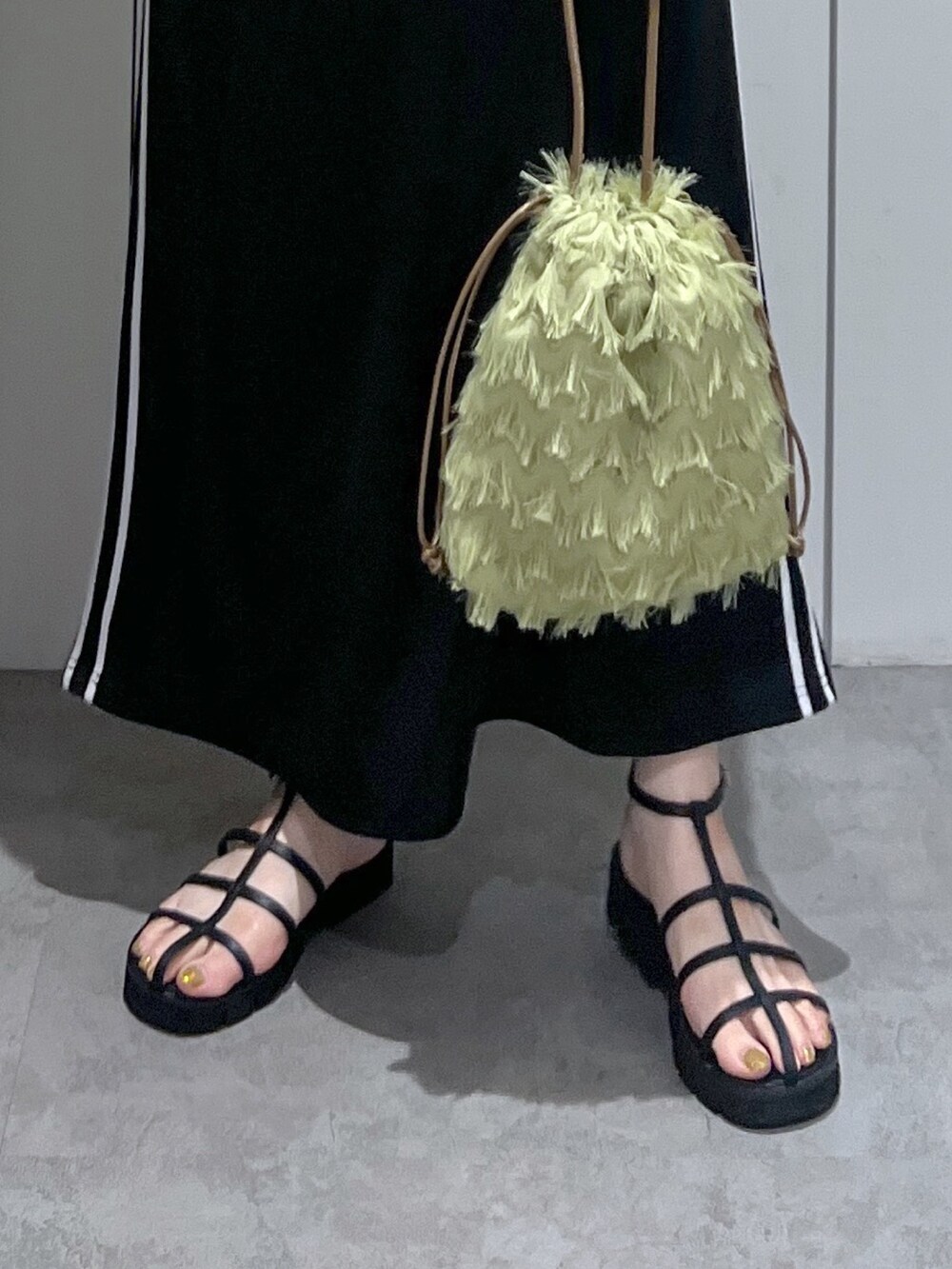 ブラック系のワンピース、ホワイト系のTシャツ/カットソー、ブラック系のサンダルを着用したレディースの夏コーディネートの6枚目の写真