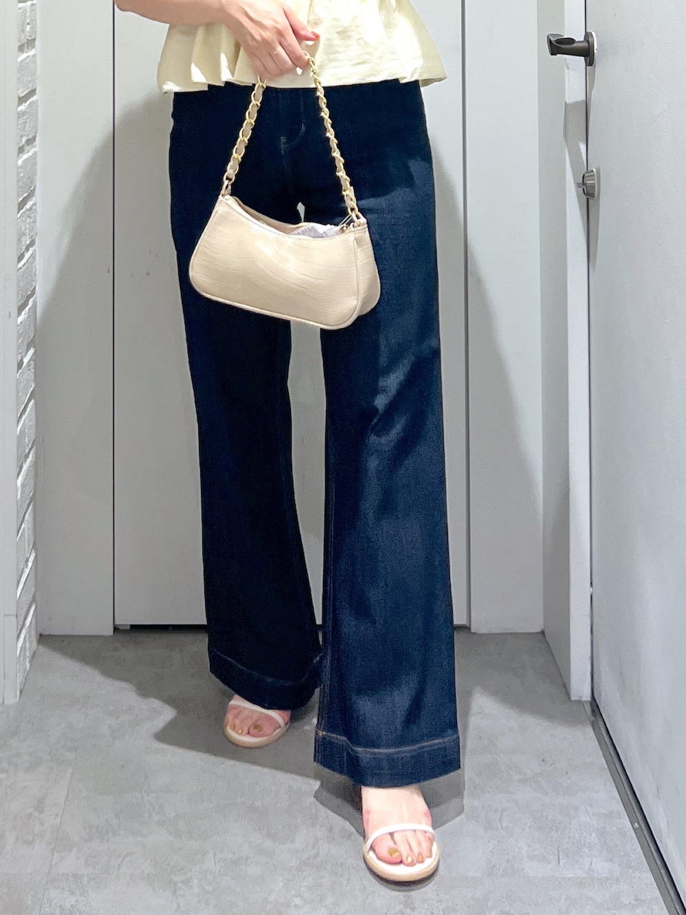 ブルー系のデニムパンツ、ベージュ系のトートバッグ、ホワイト系のシャツ/ブラウスを着用したレディースの夏コーディネートの8枚目の写真