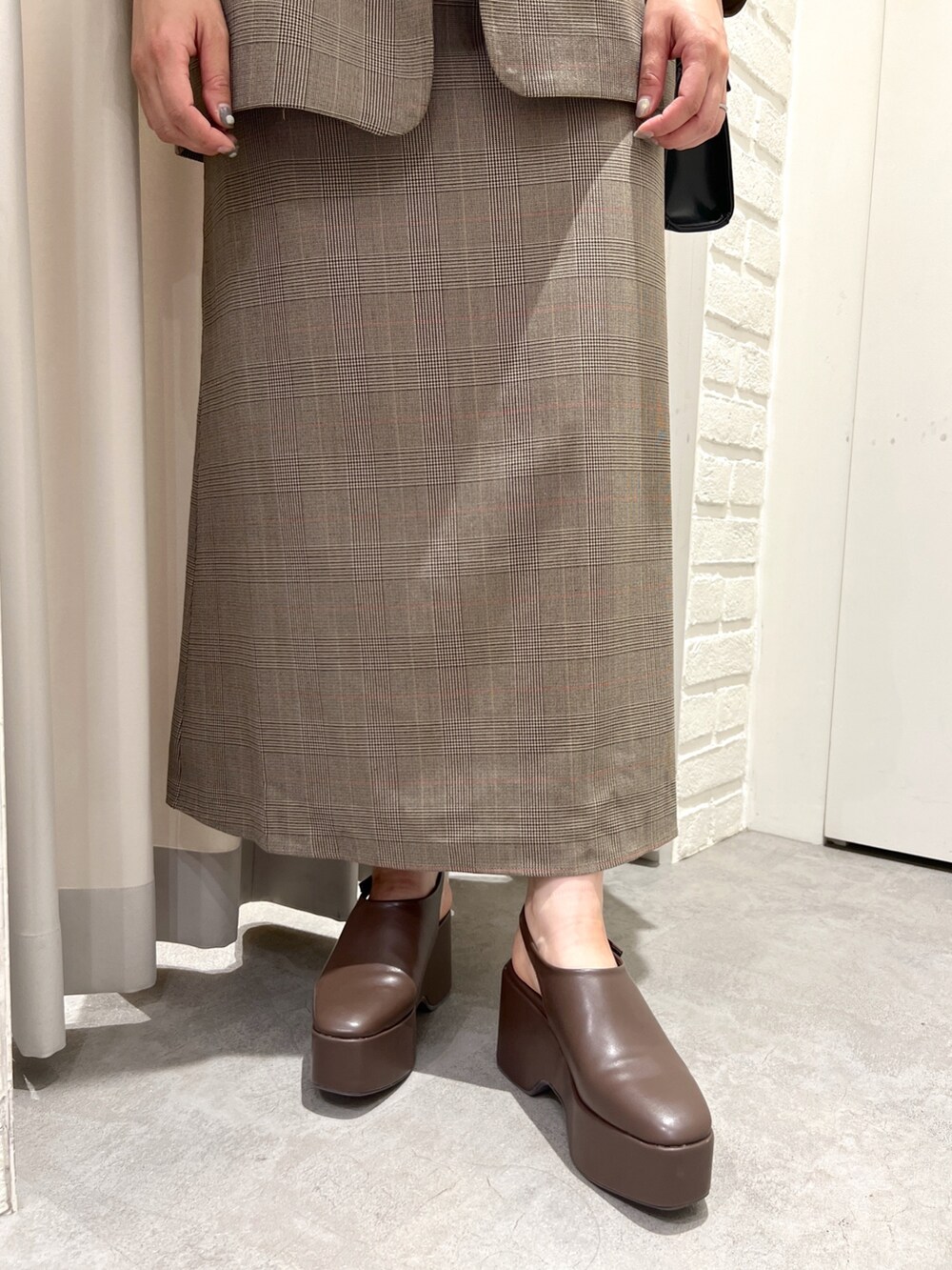 ブラウン系のテーラードジャケット、ブラウン系のワンピース、ブラウン系のサンダルを着用したレディースの秋コーディネートの4枚目の写真