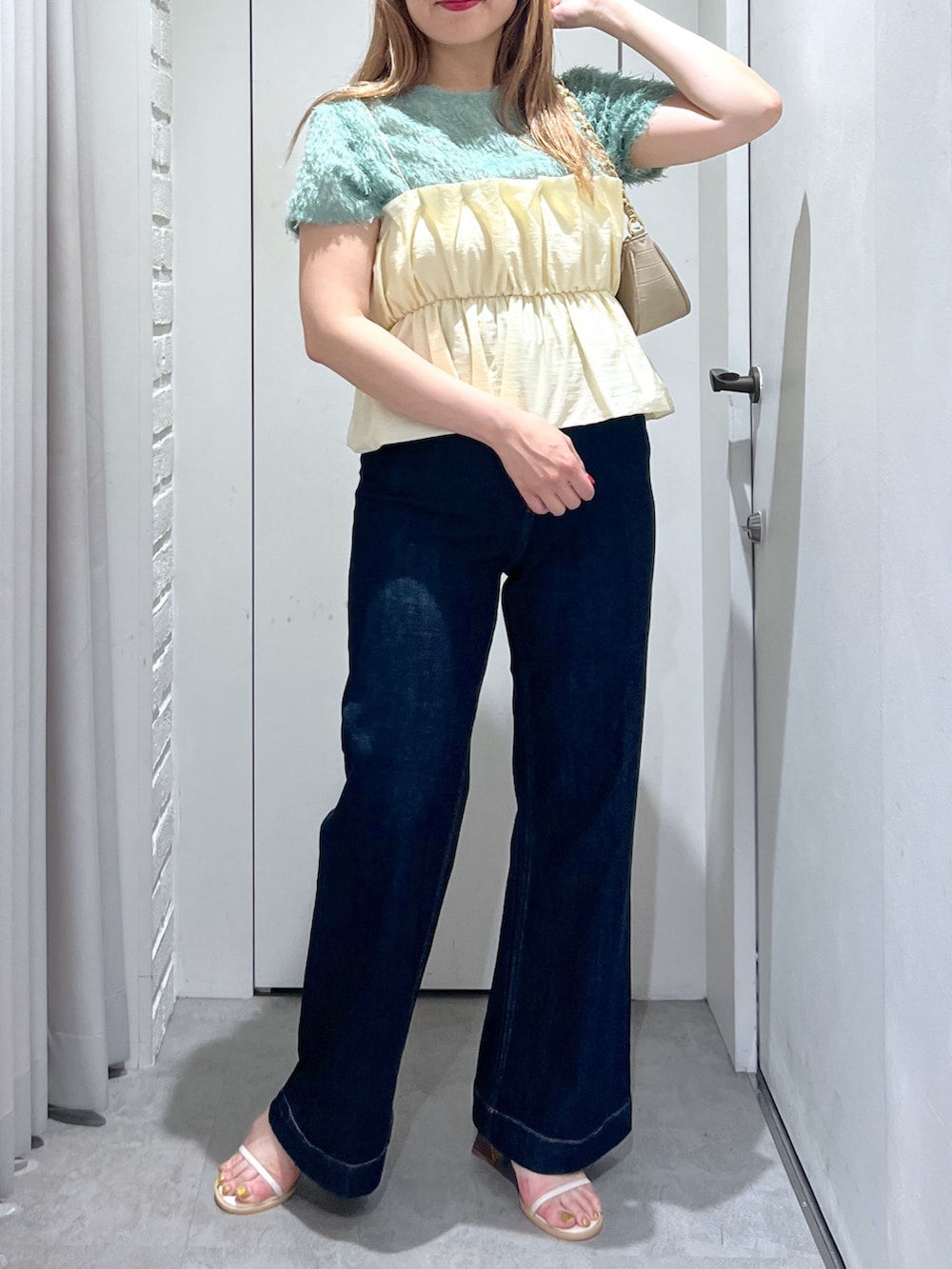 ブルー系のデニムパンツ、ベージュ系のトートバッグ、ホワイト系のシャツ/ブラウスを着用したレディースの夏コーディネートの5枚目の写真