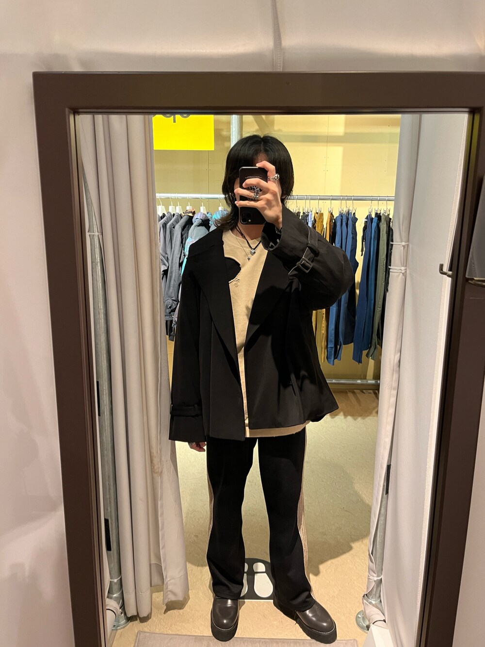 ブラック系のその他パンツ、イエロー系のトップス、ブラック系のトレンチコートを着用したメンズの春コーディネートの2枚目の写真