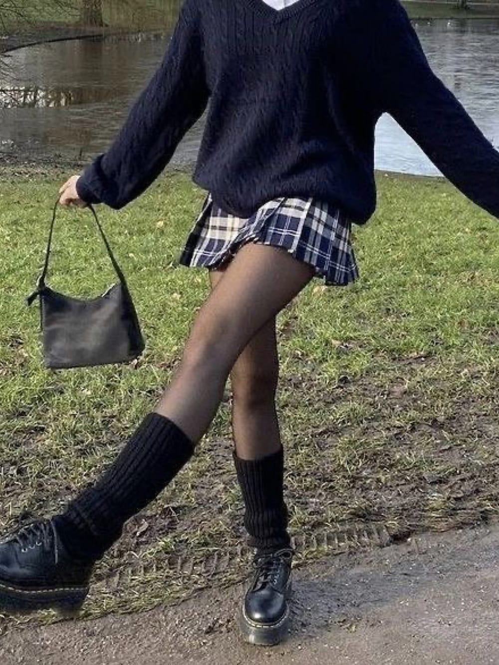 ブラウン系のスカート、ブラック系のレッグウォーマーを着用したレディースの春コーディネートの2枚目の写真