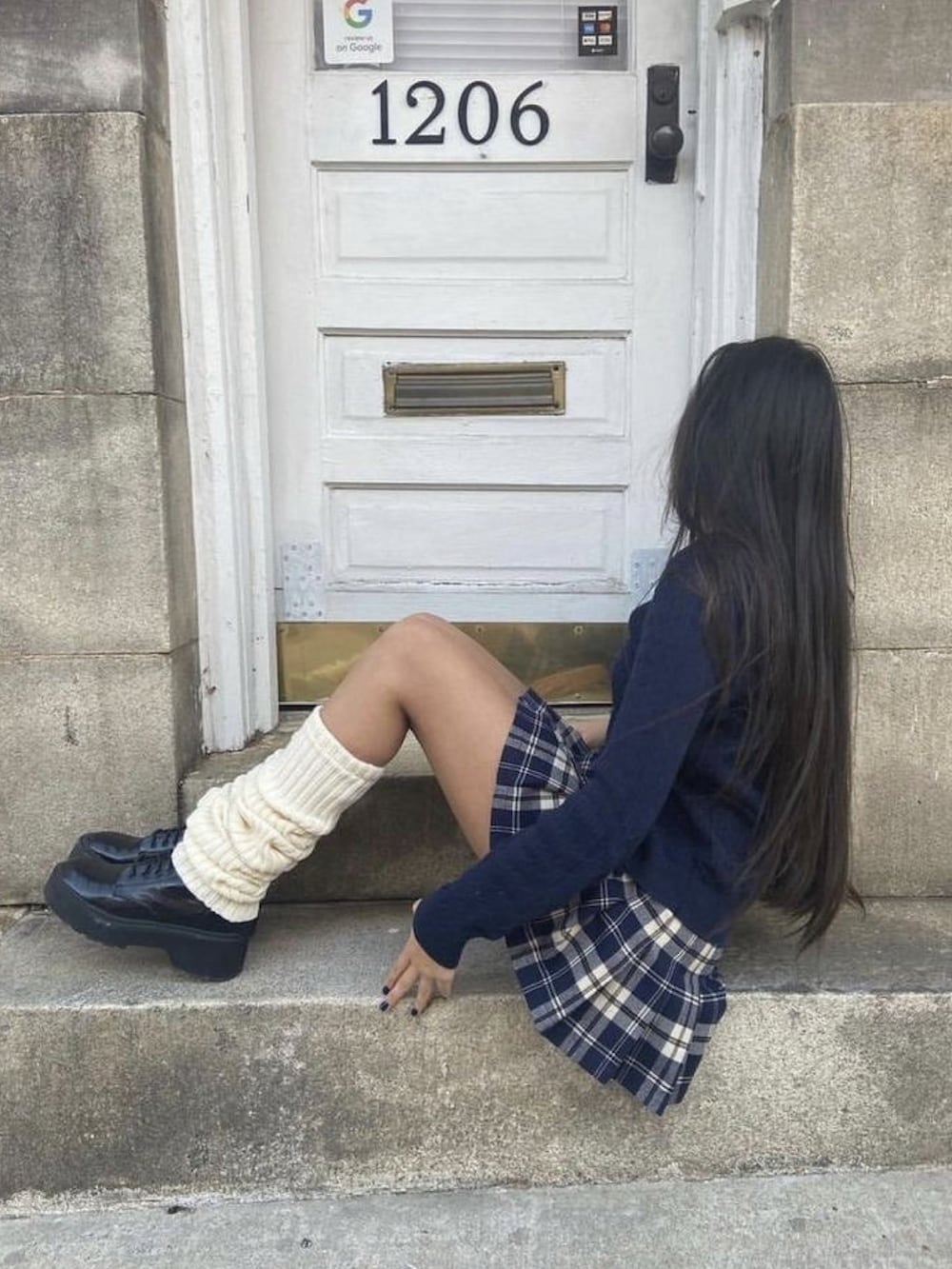 ブラウン系のスカート、ブラック系のレッグウォーマーを着用したレディースの春コーディネートの3枚目の写真