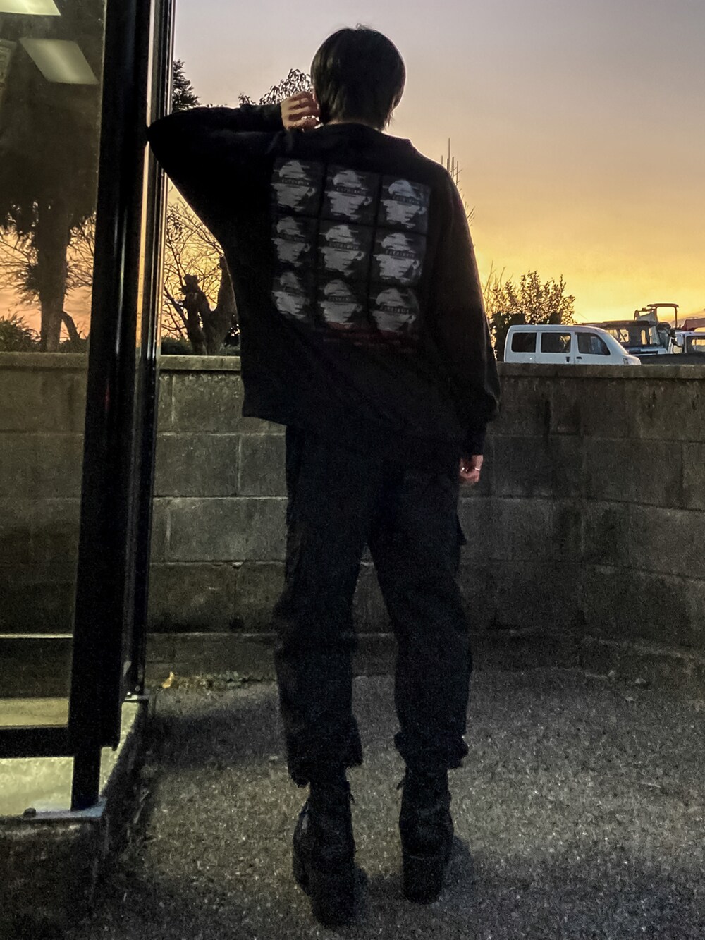 ブラック系のスウェット、ブラック系のカーゴパンツ、ブラック系のブーツを着用したメンズの冬コーディネートの2枚目の写真