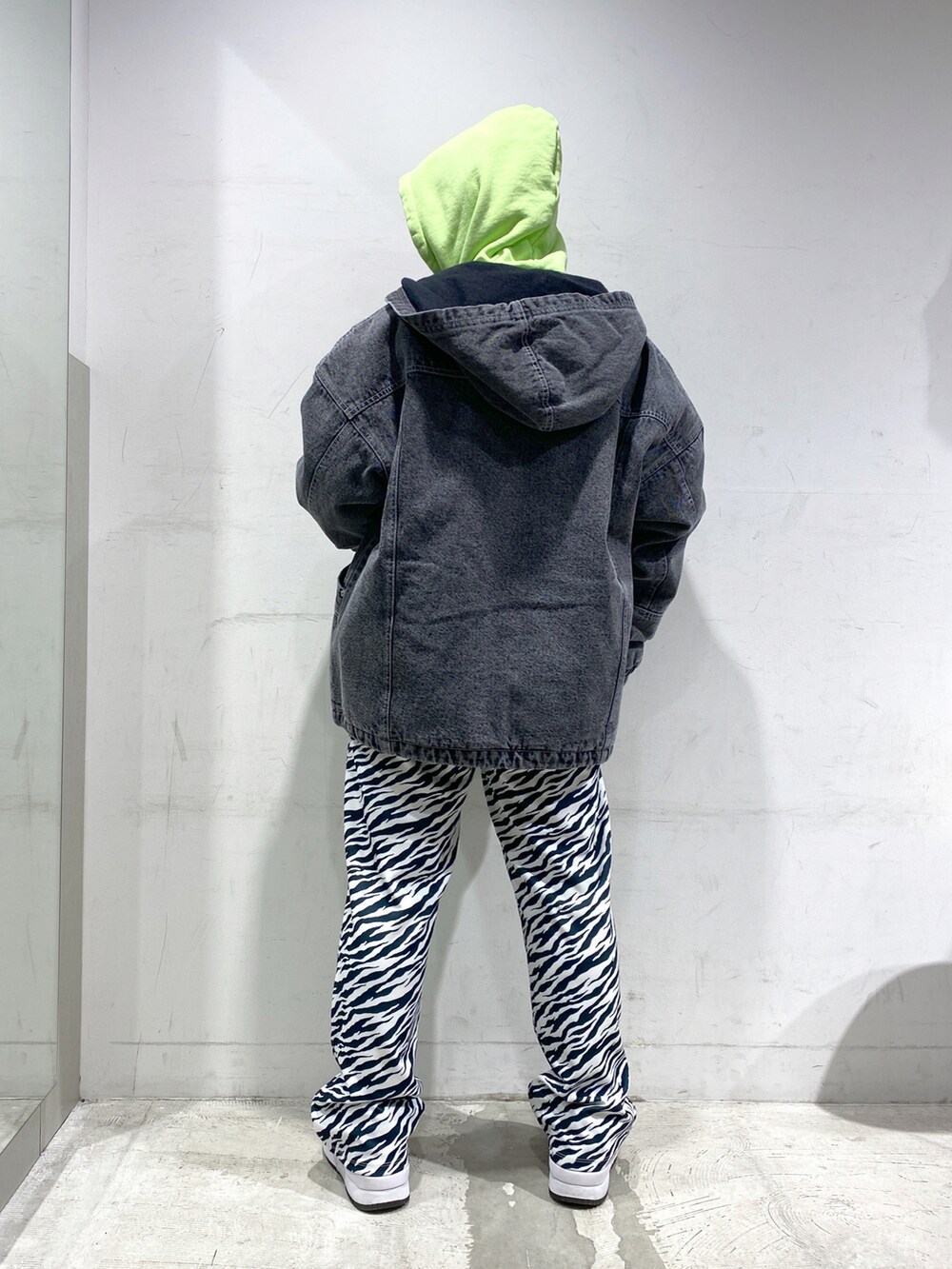 ホワイト系のその他パンツ、ブラック系のデニムジャケット、グリーン系のパーカーを着用したレディースの冬コーディネートの2枚目の写真