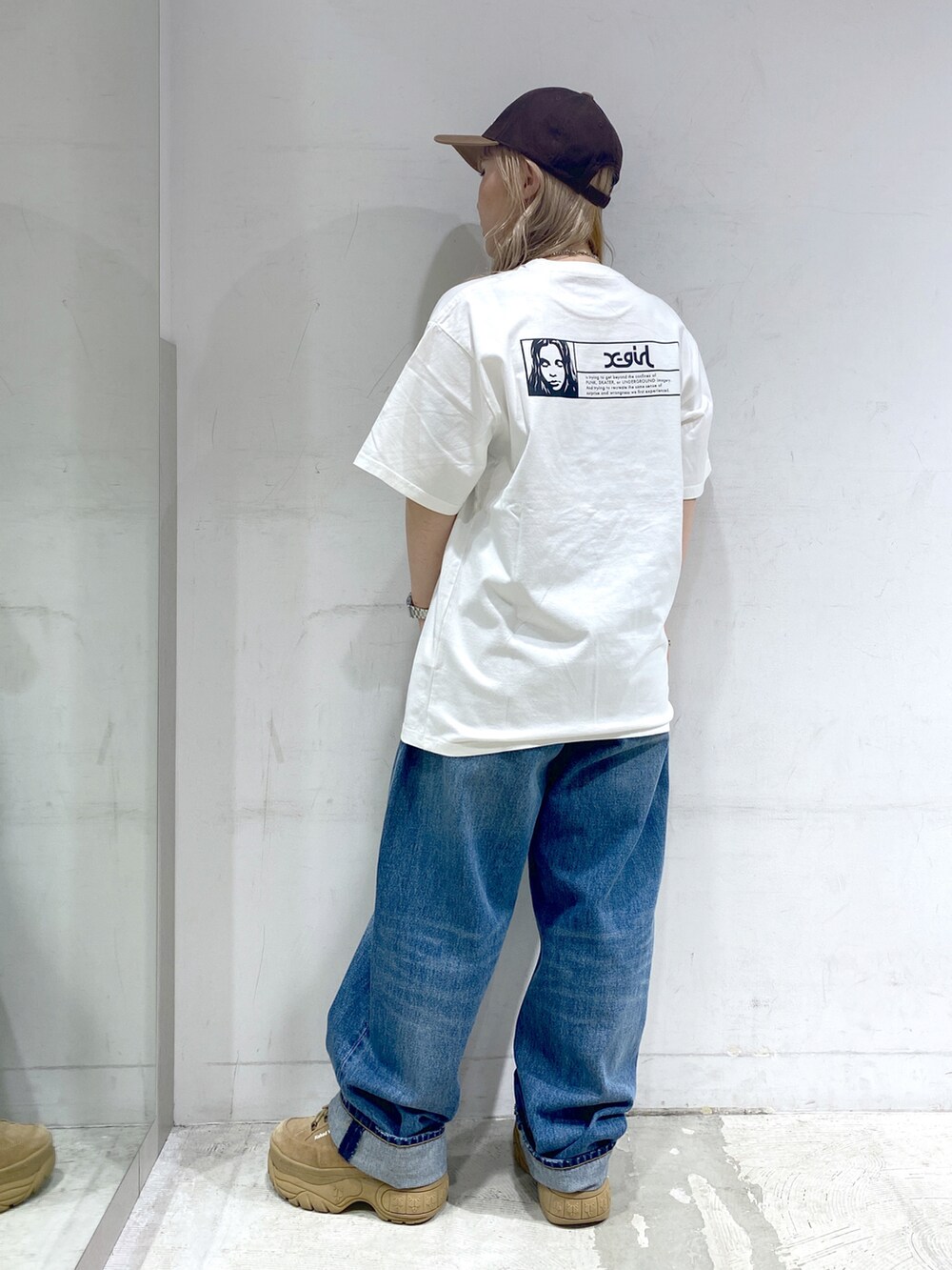 ホワイト系のTシャツ/カットソー、ブルー系のデニムパンツ、ブラウン系のキャップを着用したレディースの夏コーディネートの2枚目の写真