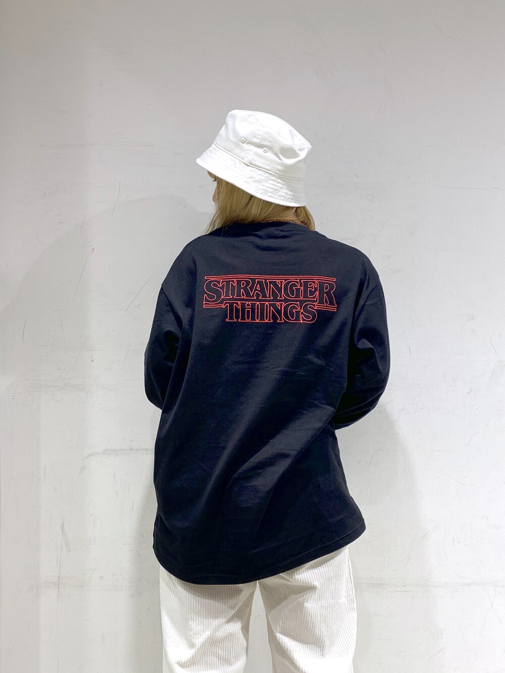 ブラック系のTシャツ/カットソー、ホワイト系のその他パンツ、ホワイト系のハットを着用したレディースの冬コーディネートの2枚目の写真