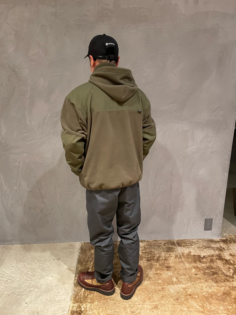 グリーン系のトップス、グレー系のデニムパンツ、ブラウン系のブーツを着用したメンズの冬コーディネートの3枚目の写真