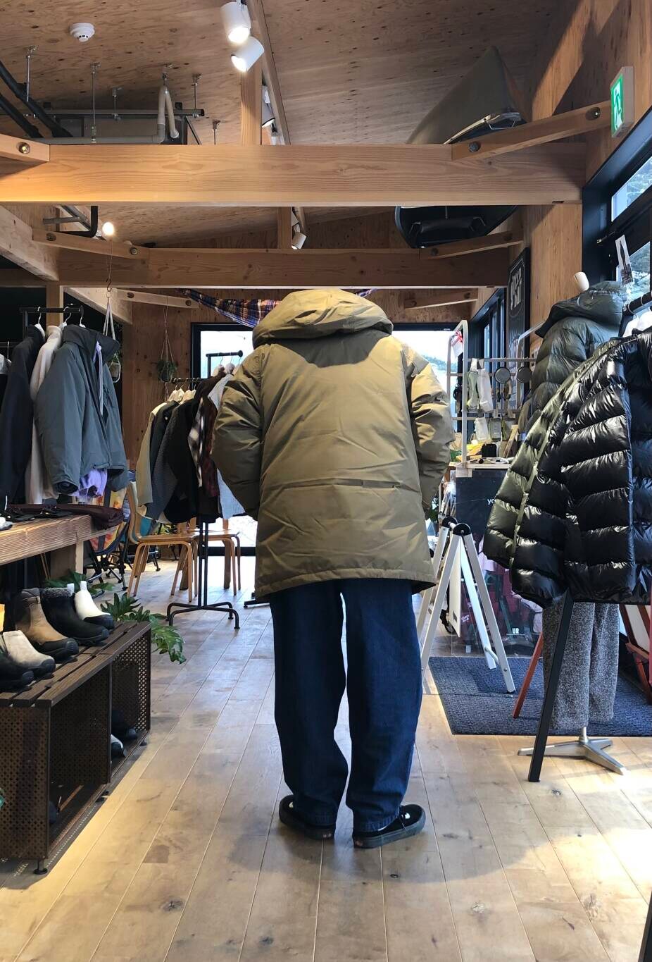 ブルー系のデニムパンツ、ブラック系のニット/セーター、ベージュ系のその他アウターを着用したメンズの冬コーディネートの3枚目の写真