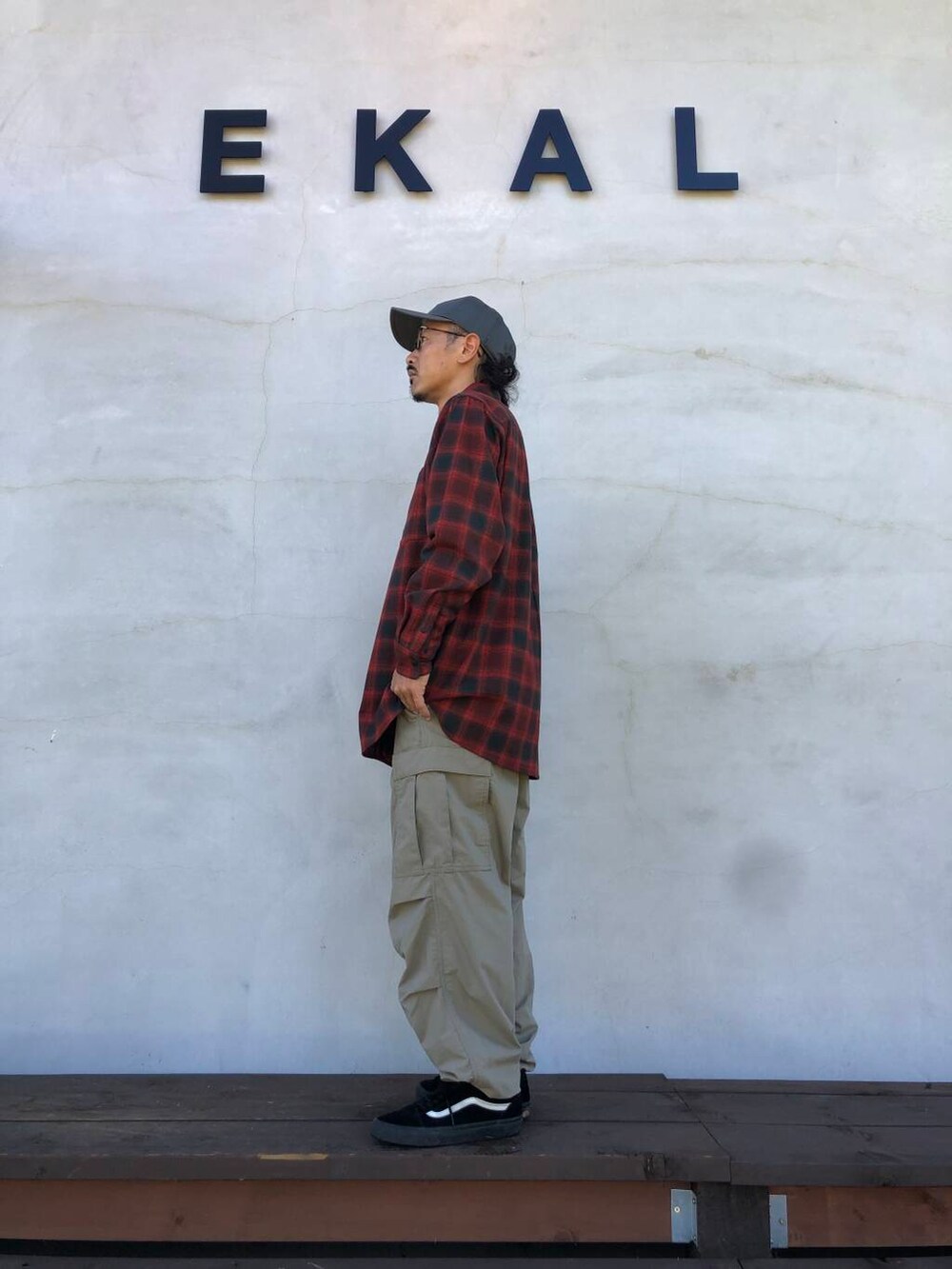 レッド系のシャツ/ブラウス、ベージュ系のその他パンツ、グレー系のキャップを着用したメンズの秋コーディネートの3枚目の写真