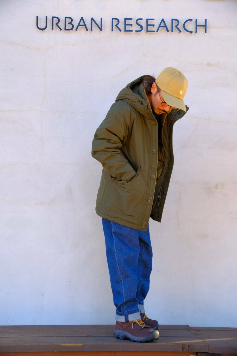 ブルー系のデニムパンツ、ブルー系のニット/セーター、グリーン系のその他アウターを着用したメンズの冬コーディネートの2枚目の写真