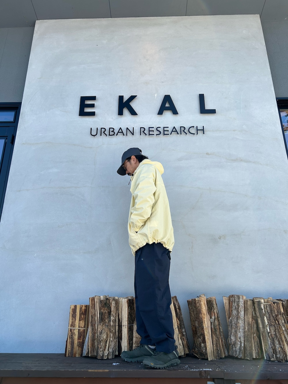 ブラック系のカーディガン/ボレロ、イエロー系のナイロンジャケット、ブルー系のその他パンツを着用したメンズの冬コーディネートの3枚目の写真