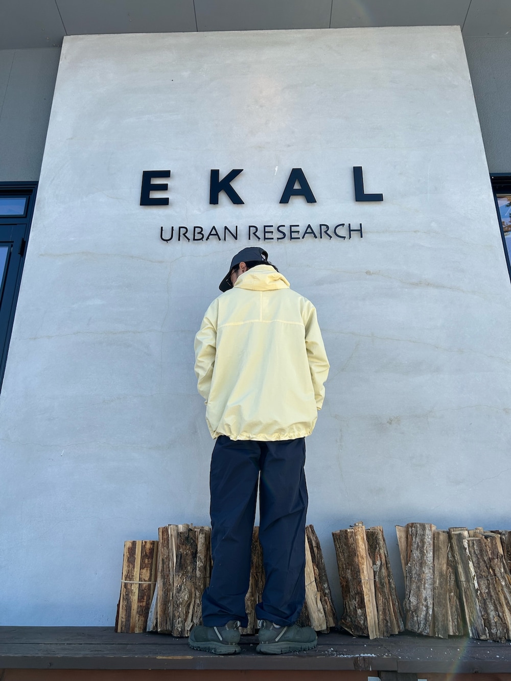 ブラック系のカーディガン/ボレロ、イエロー系のナイロンジャケット、ブルー系のその他パンツを着用したメンズの冬コーディネートの2枚目の写真