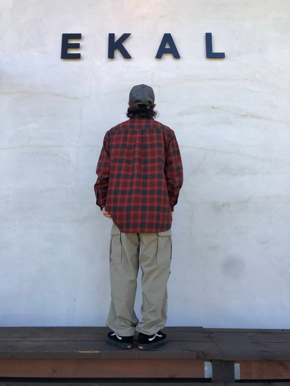 レッド系のシャツ/ブラウス、ベージュ系のその他パンツ、グレー系のキャップを着用したメンズの秋コーディネートの2枚目の写真