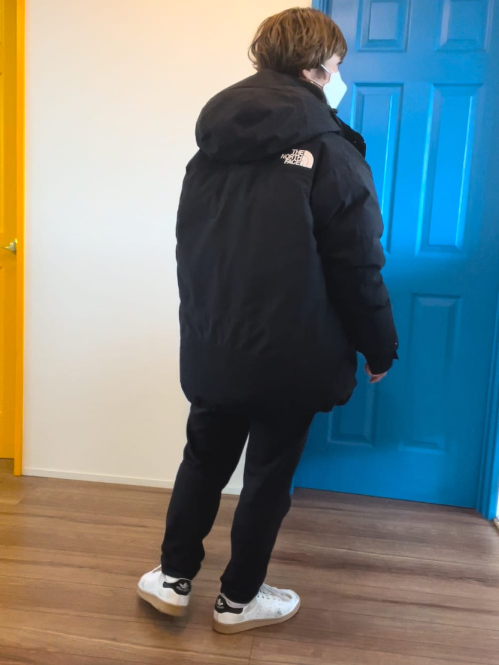 ブラック系のダウンジャケット/コート、ブラック系のパーカー、ホワイト系のTシャツ/カットソーを着用したレディースの冬コーディネートの2枚目の写真