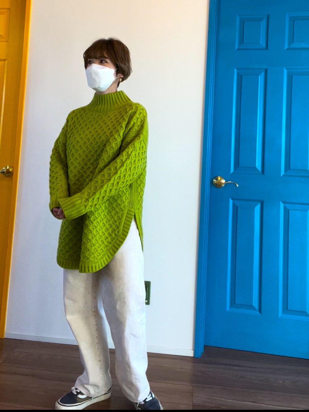 グレー系のニット/セーター、ホワイト系のデニムパンツ、グリーン系のスニーカーを着用したレディースの冬コーディネートの2枚目の写真