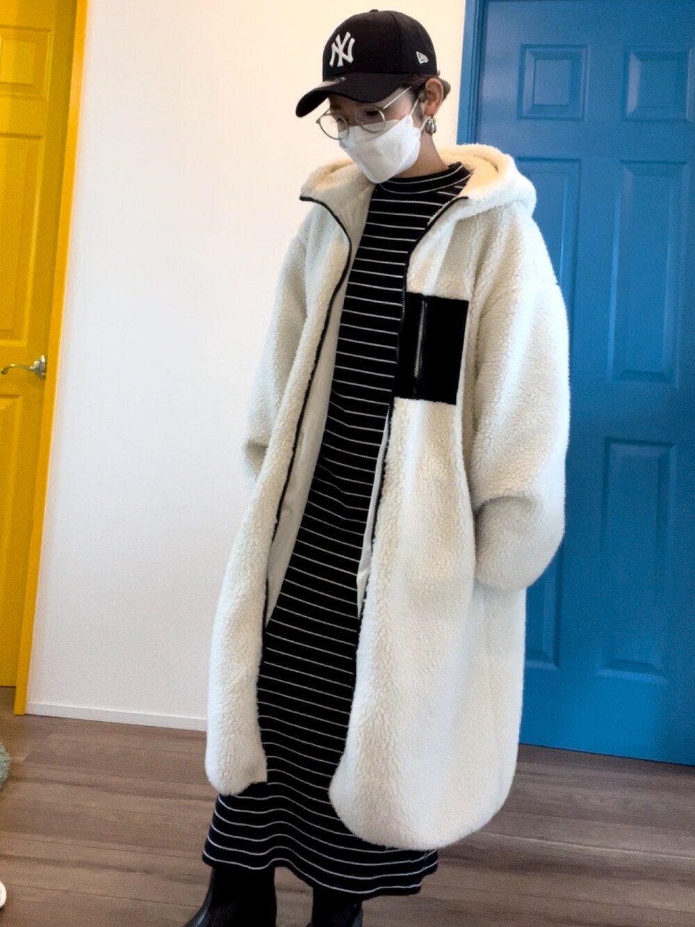 ブルー系のワンピース/ドレス、ホワイト系のノーカラーコート、ブラック系のブーツを着用したレディースの冬コーディネートの3枚目の写真