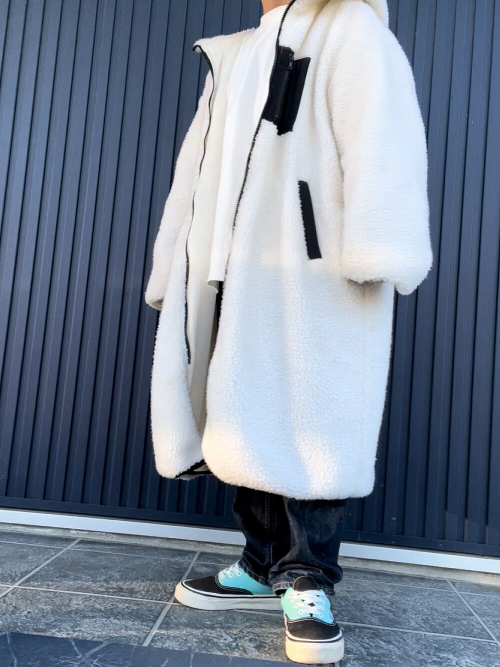 ホワイト系のTシャツ/カットソー、ブルー系のデニムパンツ、ブルー系のスニーカーを着用したレディースの冬コーディネートの4枚目の写真