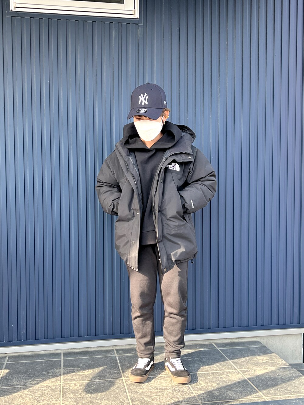 ブラック系のスニーカー、ブラック系のスウェットパンツ、ブラック系のダウンジャケット/コートを着用したレディースの冬コーディネートの2枚目の写真