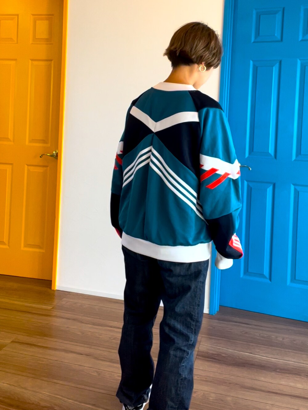 ホワイト系のトップス、ブルー系のデニムパンツ、ホワイト系のスニーカーを着用したレディースの冬コーディネートの3枚目の写真