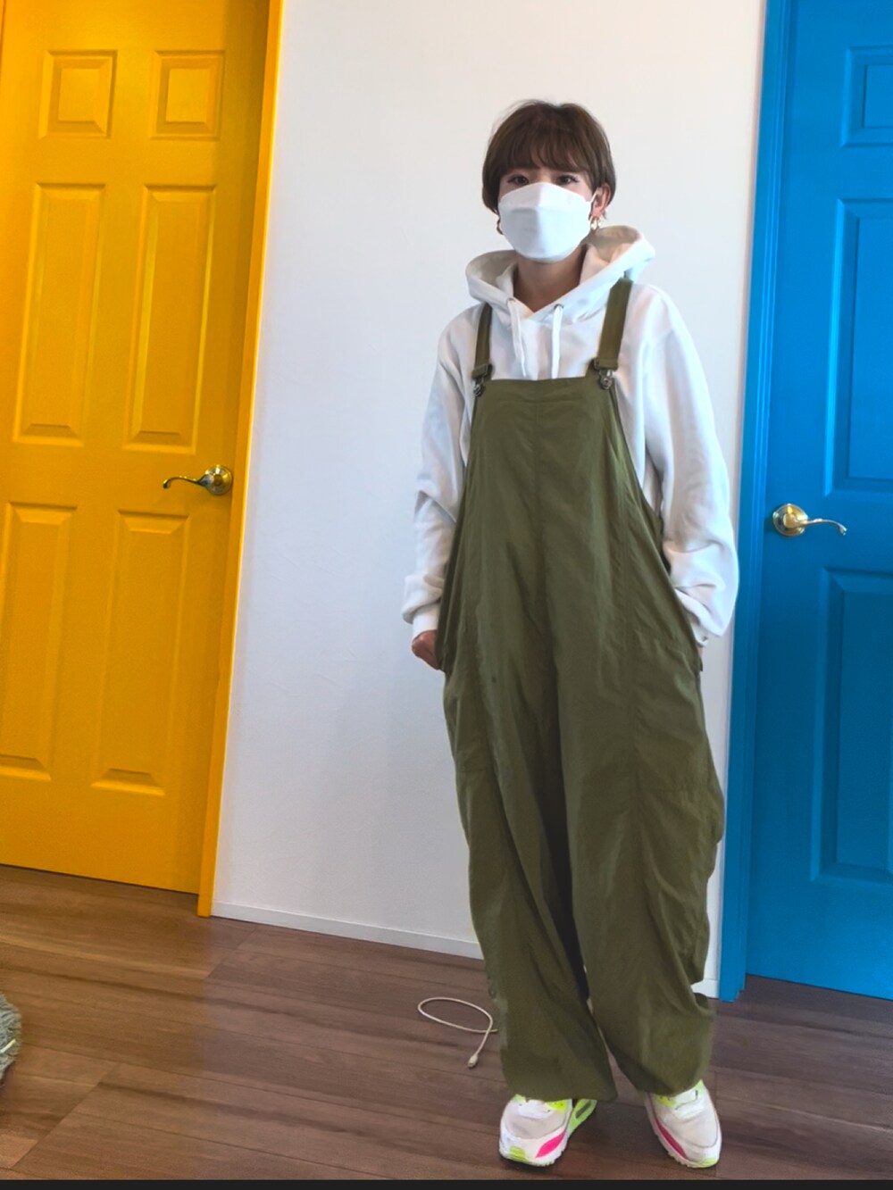 グリーン系のつなぎ/オールインワン、ホワイト系のパーカー、ホワイト系のスニーカーを着用したレディースの冬コーディネートの2枚目の写真