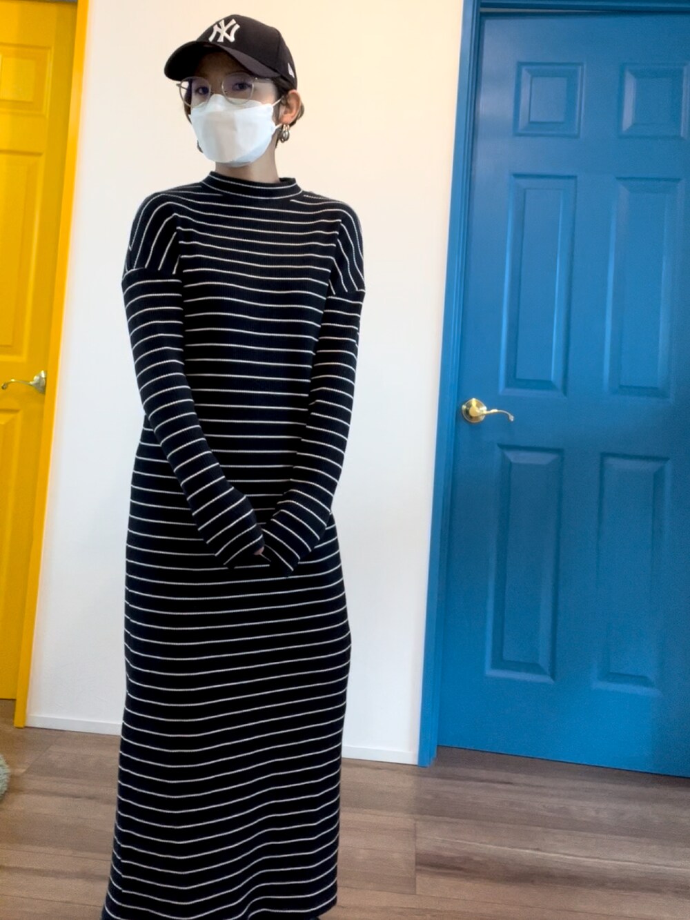 ブルー系のワンピース/ドレス、ホワイト系のノーカラーコート、ブラック系のブーツを着用したレディースの冬コーディネートの2枚目の写真