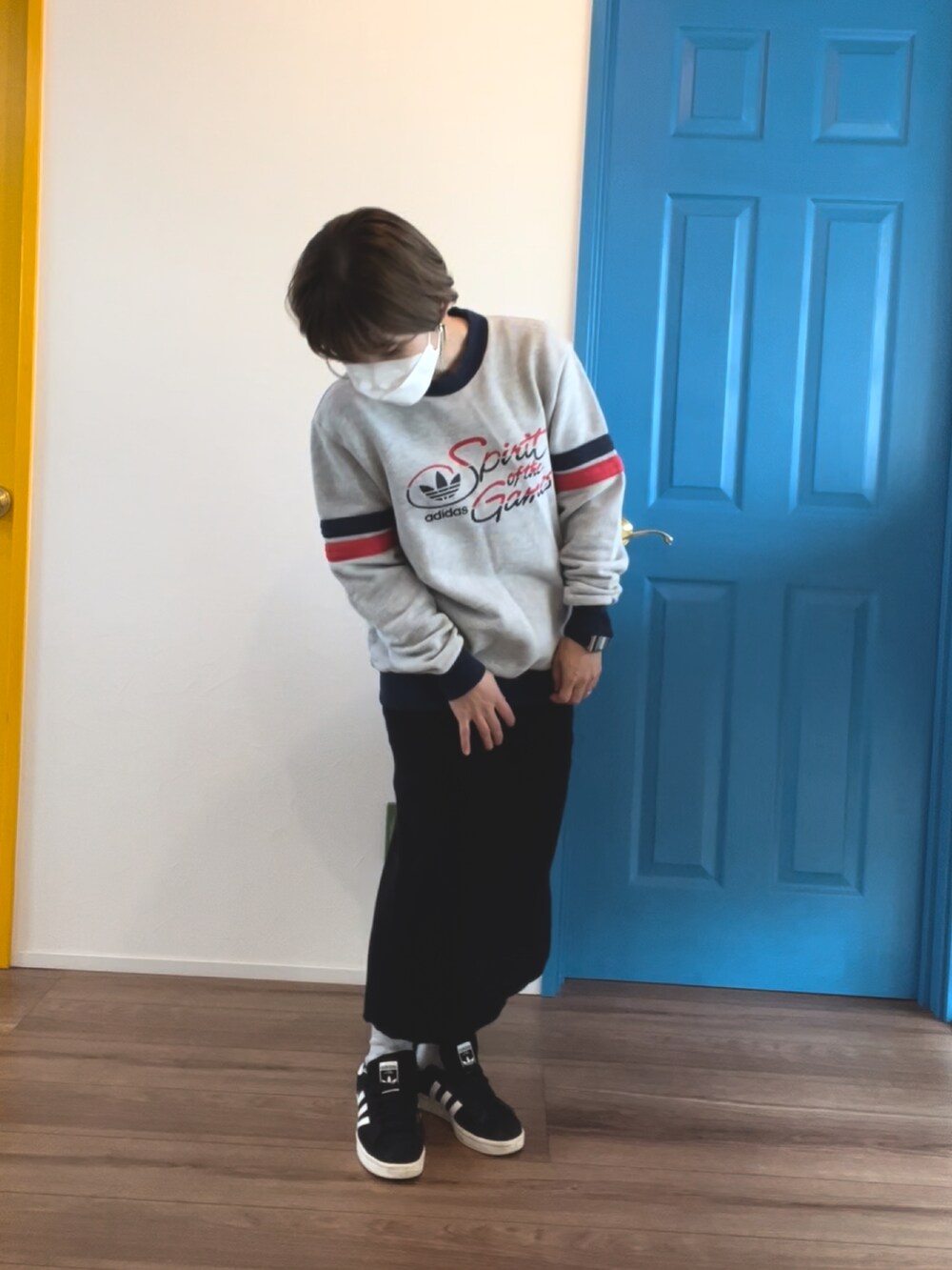 グレー系のスウェット、ホワイト系のノーカラーコート、ブラック系のスニーカーを着用したレディースの冬コーディネートの2枚目の写真