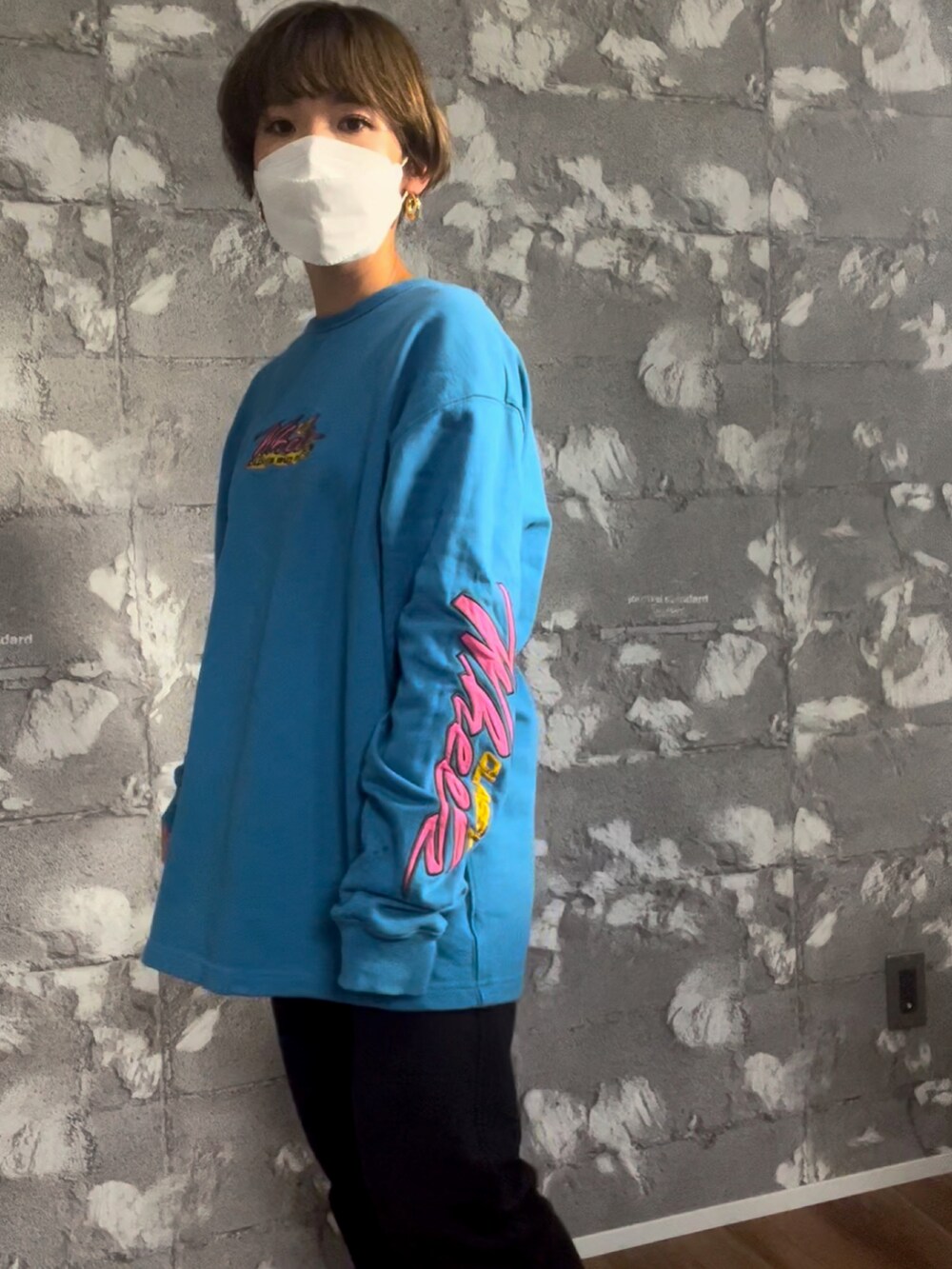 ブルー系のTシャツ/カットソー、ブラック系のデニムパンツ、ホワイト系のスニーカーを着用したレディースの冬コーディネートの2枚目の写真