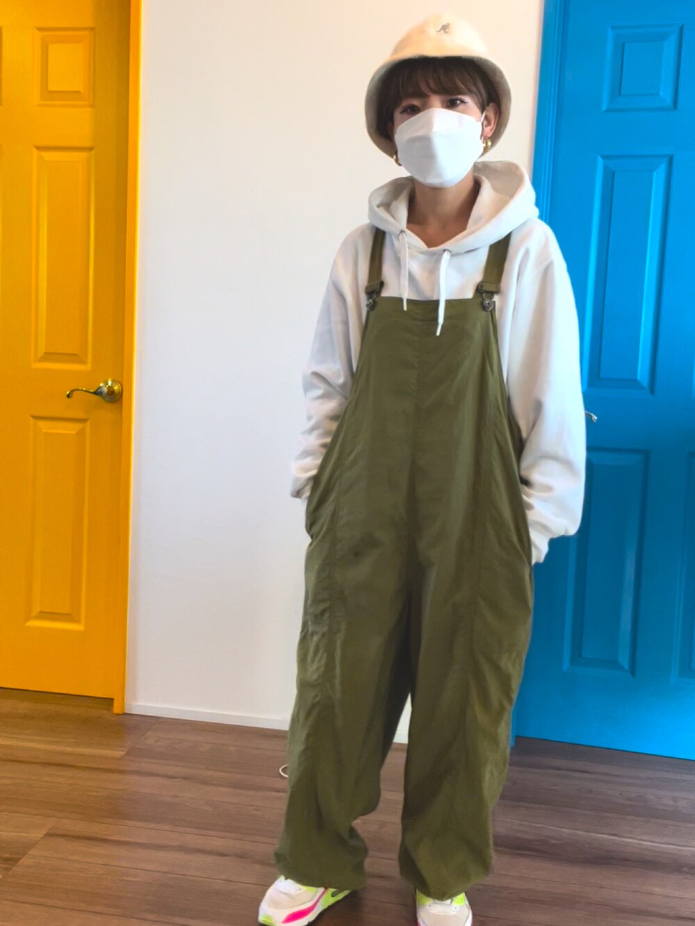 グリーン系のつなぎ/オールインワン、ホワイト系のパーカー、ホワイト系のスニーカーを着用したレディースの冬コーディネートの3枚目の写真