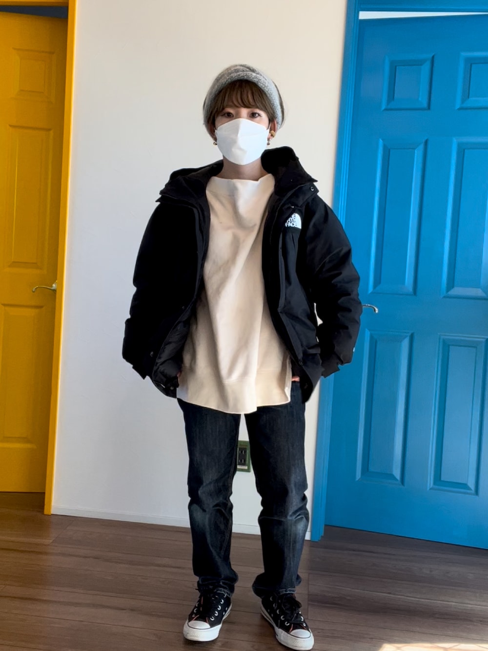 ブラック系のダウンジャケット/コート、ホワイト系のスウェット、ブルー系のデニムパンツを着用したレディースの冬コーディネートの3枚目の写真