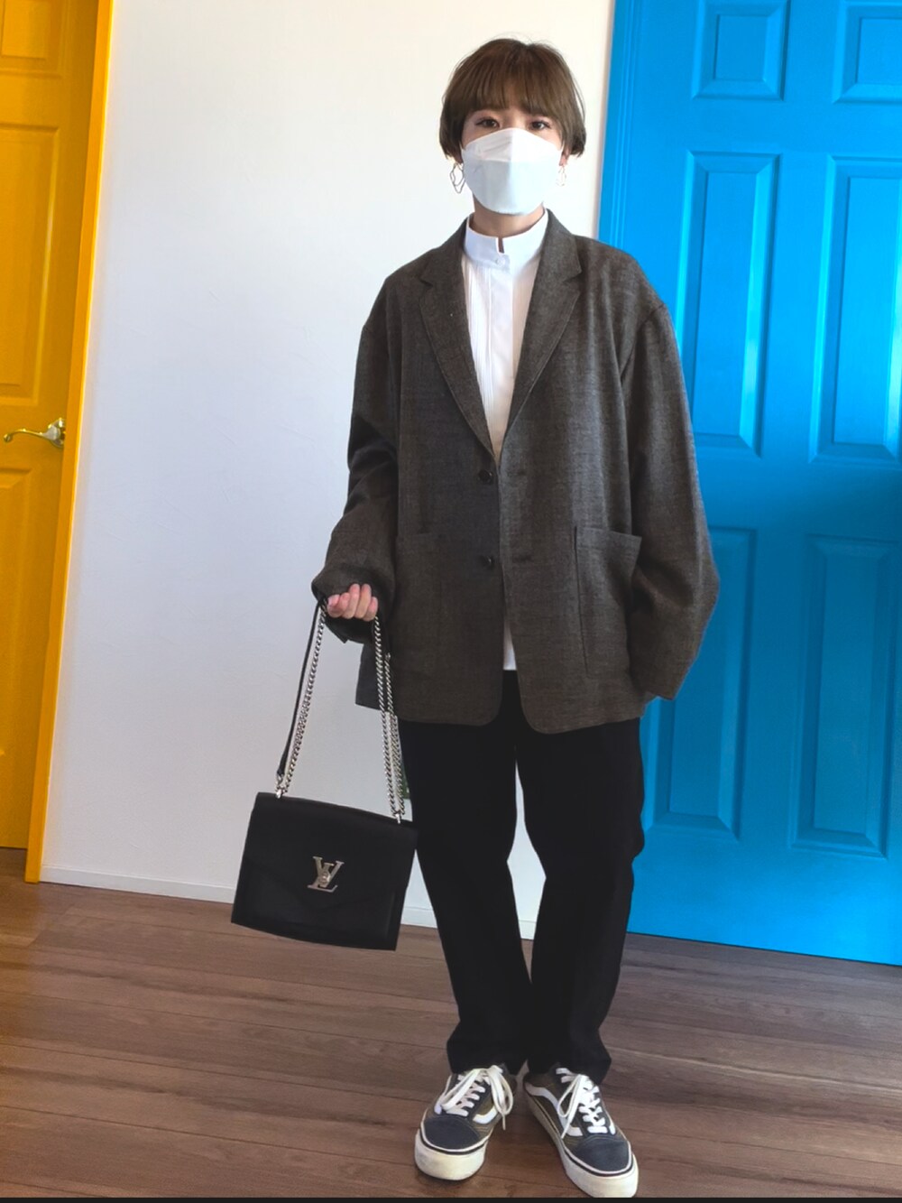 ホワイト系のノーカラーコート、ブラック系のバッグ、ブラウン系のテーラードジャケットを着用したレディースの冬コーディネートの3枚目の写真