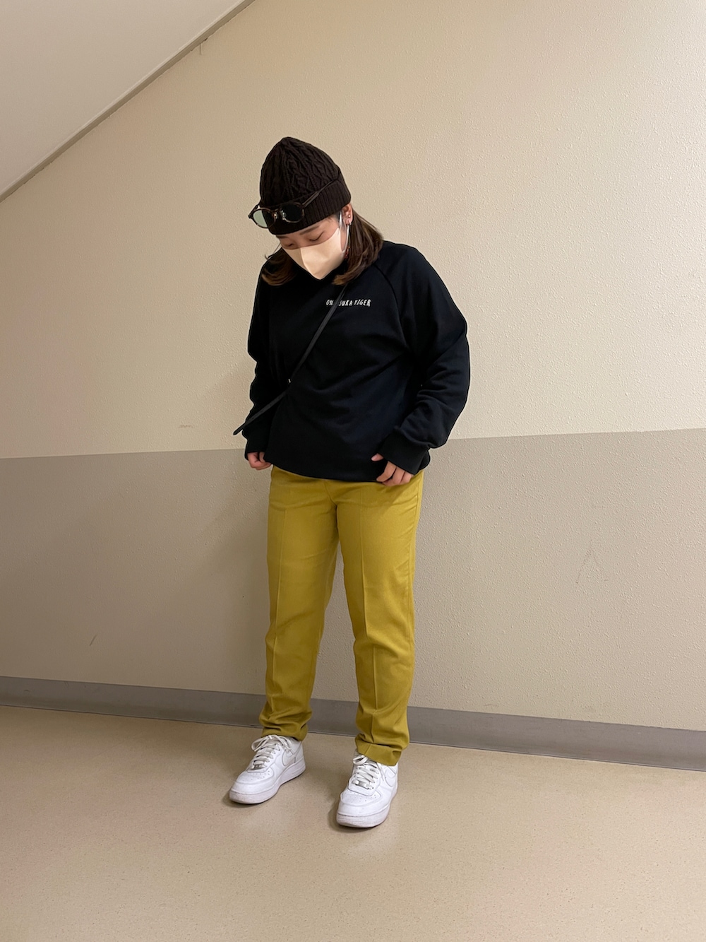 ブラック系のスウェット、イエロー系のその他パンツ、ホワイト系のスニーカーを着用したレディースの秋コーディネートの2枚目の写真