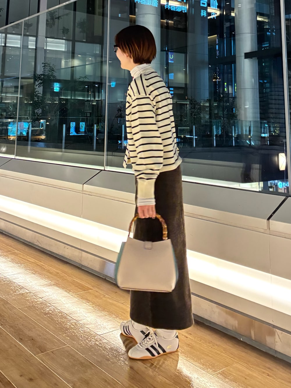 ホワイト系のカーディガン/ボレロ、グリーン系のTシャツ/カットソー、ブラウン系のスカートを着用したレディースの秋コーディネートの2枚目の写真