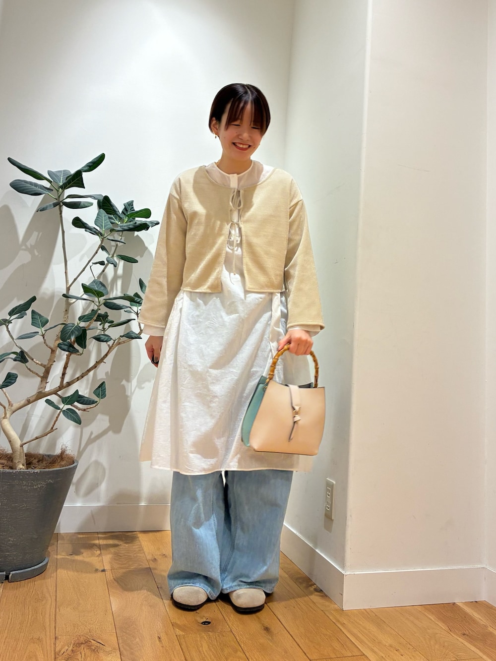 ベージュ系のカーディガン/ボレロ、ホワイト系のチュニック、ホワイト系のハンドバッグを着用したレディースの秋コーディネートの4枚目の写真