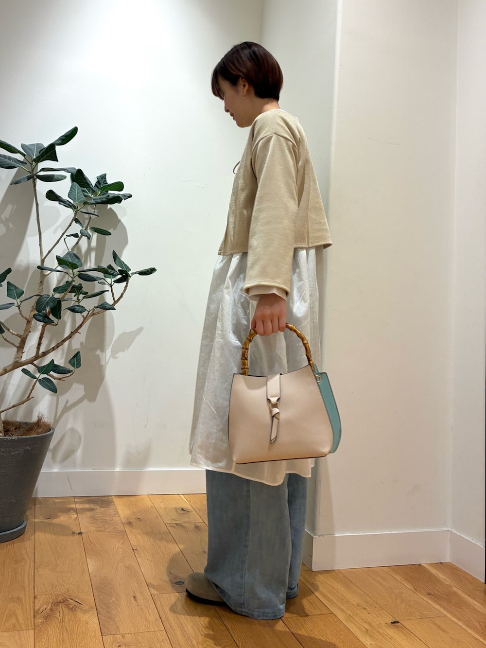 ベージュ系のカーディガン/ボレロ、ホワイト系のチュニック、ホワイト系のハンドバッグを着用したレディースの秋コーディネートの2枚目の写真