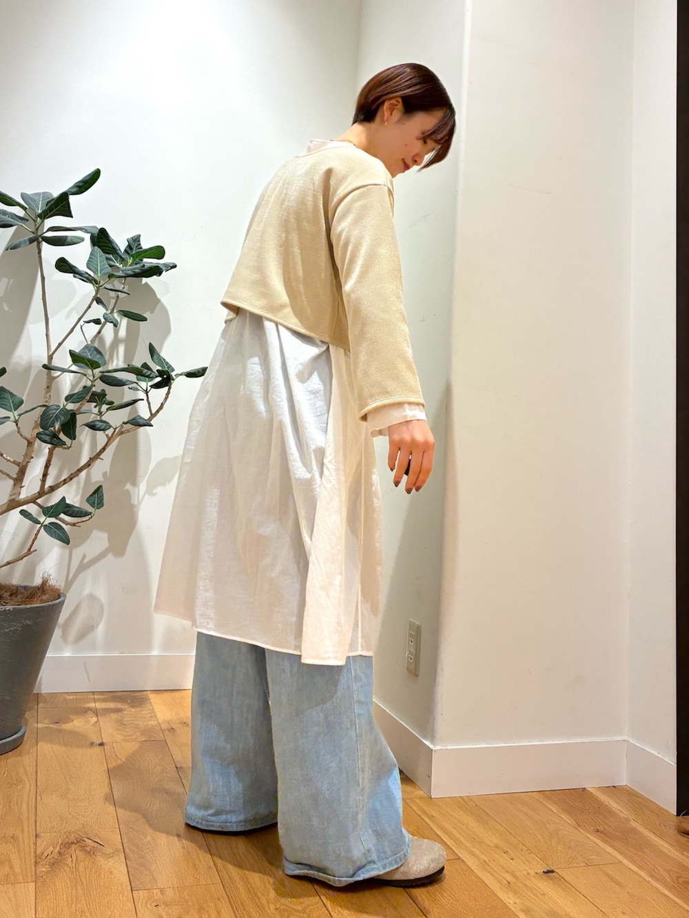 ベージュ系のカーディガン/ボレロ、ホワイト系のチュニック、ホワイト系のハンドバッグを着用したレディースの秋コーディネートの3枚目の写真