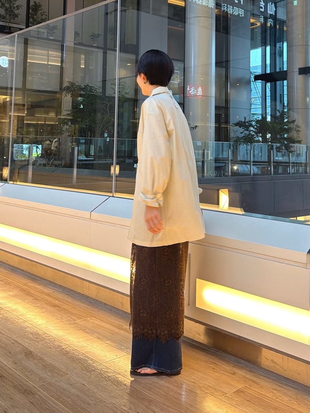 ブラック系のサンダル、ブルー系のデニムパンツ、ブラウン系のスカートを着用したレディースの夏コーディネートの3枚目の写真