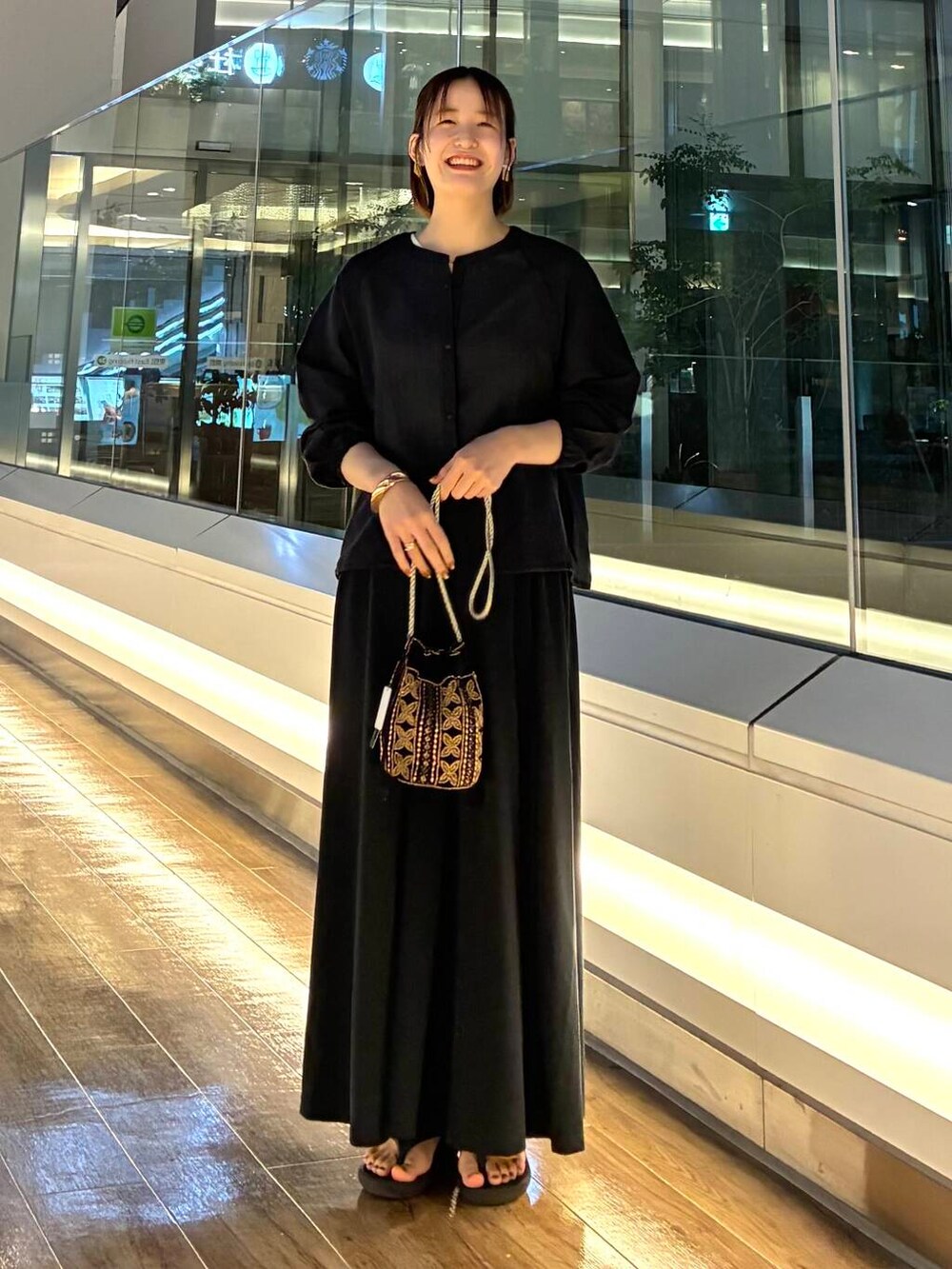 ブラック系のショルダーバッグ、ブラック系のスカート、ブラック系のカーディガン/ボレロを着用したレディースの夏コーディネートの4枚目の写真